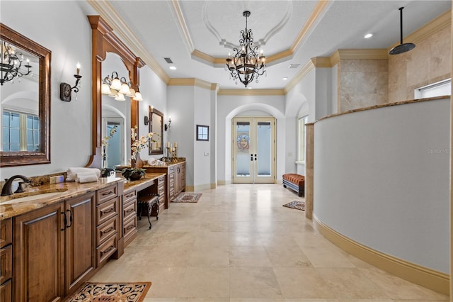 bathroom featuring vanity, an inviting chandelier, french doors, crown molding, and a tray ceiling