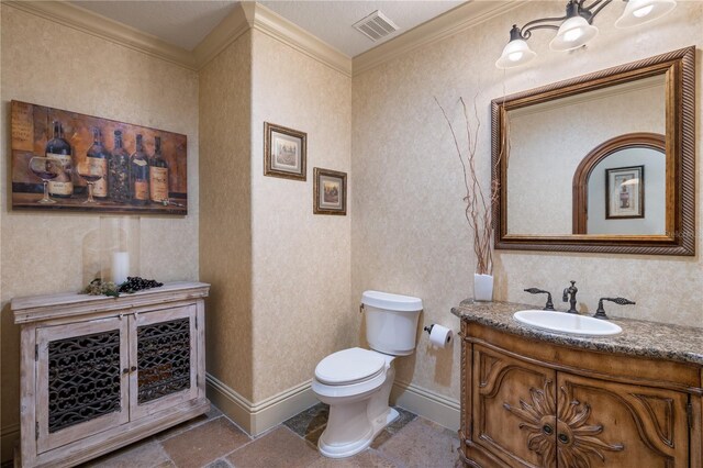 bathroom with a textured ceiling, vanity, toilet, and crown molding