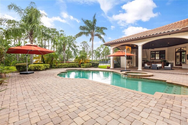 view of swimming pool featuring an in ground hot tub, a patio, and ceiling fan