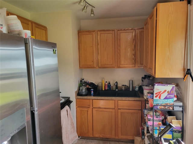 kitchen with stainless steel fridge, sink, and light tile patterned floors