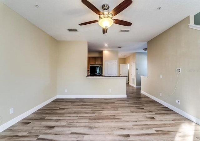 unfurnished living room featuring ceiling fan and light hardwood / wood-style flooring