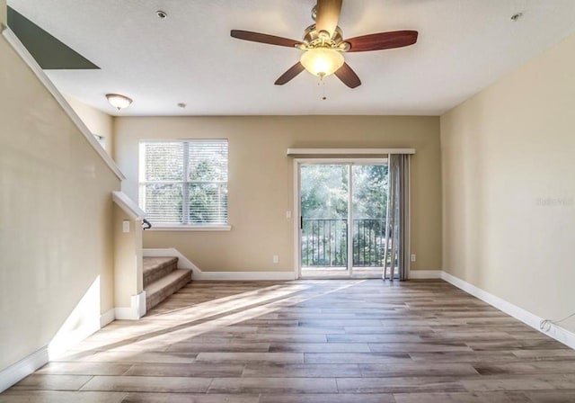 unfurnished living room featuring ceiling fan, a healthy amount of sunlight, and wood-type flooring