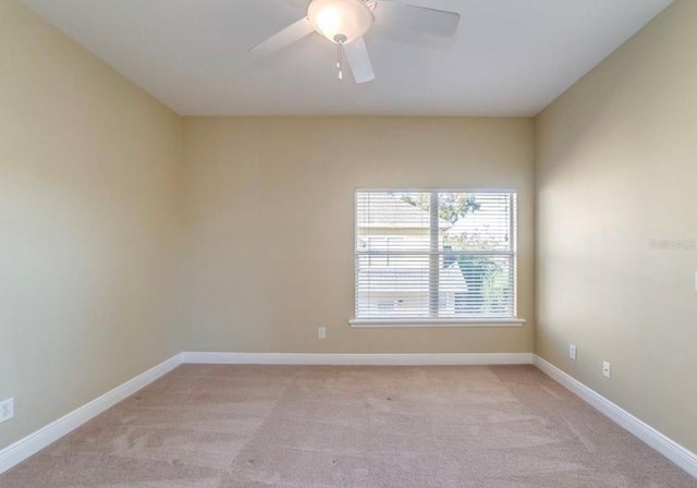 carpeted spare room featuring ceiling fan