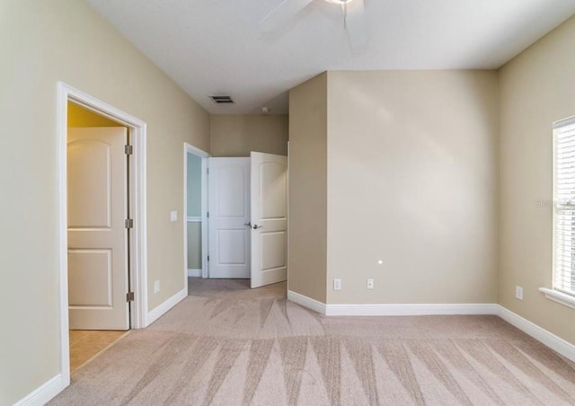 unfurnished bedroom featuring ceiling fan and light colored carpet