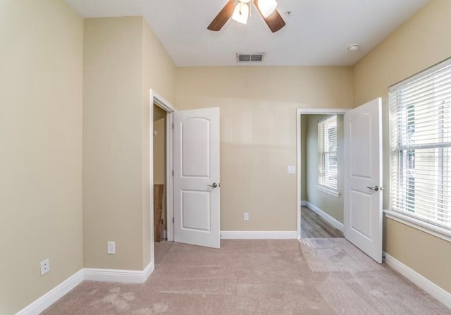 unfurnished bedroom with ceiling fan and light colored carpet