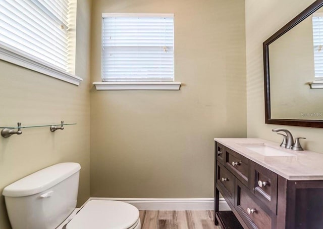 bathroom with toilet, hardwood / wood-style flooring, and vanity