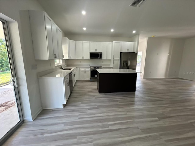 7539 Bernal Dr, Sebring, FL 33872 - kitchen featuring stainless steel appliances, baseboards, a sink, a center island, and light wood-type flooring