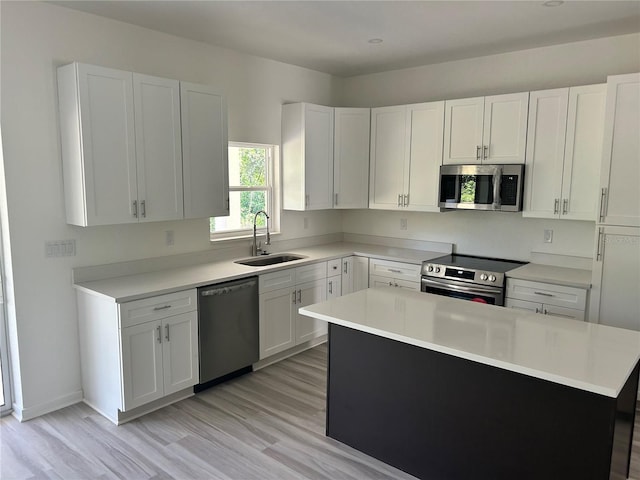 7539 Bernal Dr, Sebring, FL 33872 - kitchen with stainless steel appliances, a sink, white cabinets, light wood finished floors, and light countertops