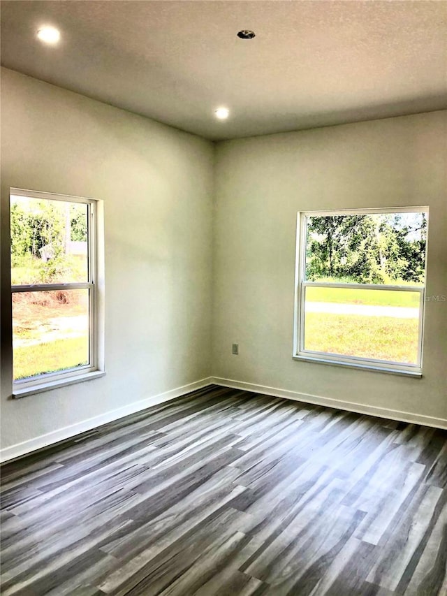 7539 Bernal Dr, Sebring, FL 33872 - spare room with healthy amount of natural light, dark wood-type flooring, recessed lighting, and baseboards