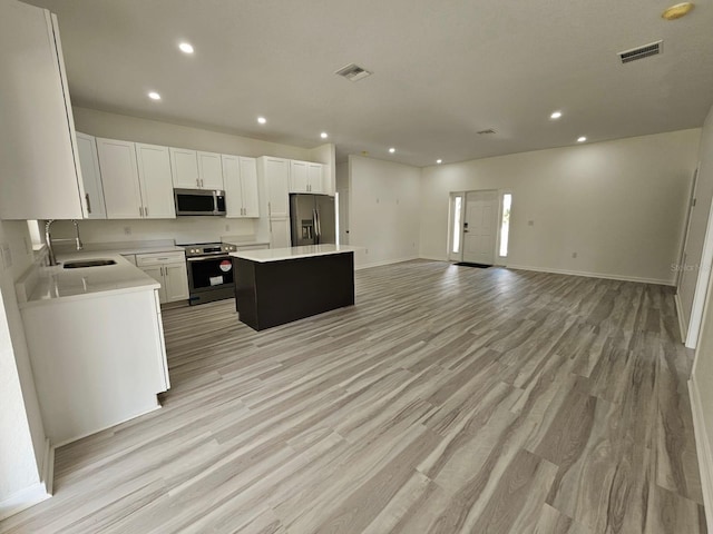7539 Bernal Dr, Sebring, FL 33872 - kitchen featuring stainless steel appliances, a sink, a kitchen island, recessed lighting, and light countertops