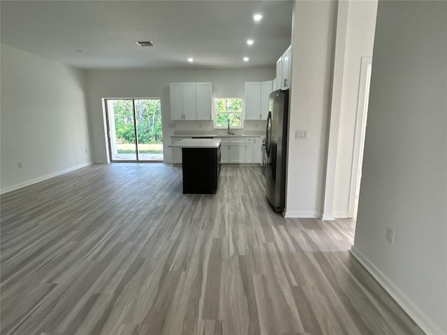 7539 Bernal Dr, Sebring, FL 33872 - kitchen with freestanding refrigerator, open floor plan, a sink, light wood-style floors, and a center island