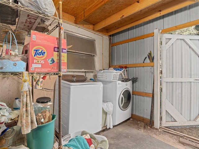 washroom featuring laundry area, metal wall, and washing machine and clothes dryer