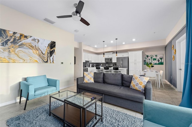 living room featuring light tile patterned floors, baseboards, visible vents, ceiling fan, and recessed lighting