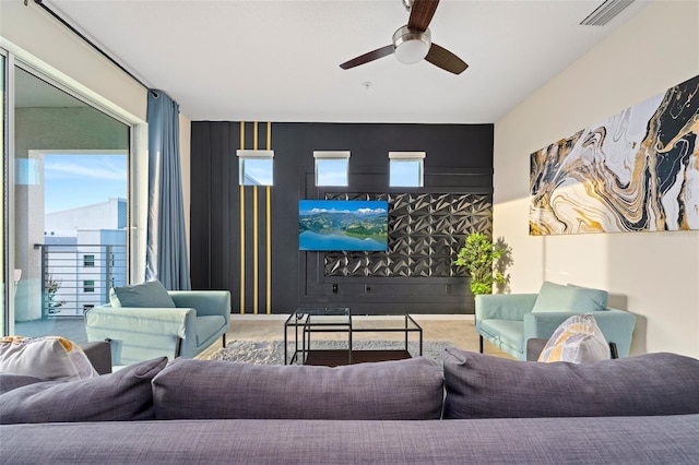 living room featuring plenty of natural light, visible vents, and a ceiling fan