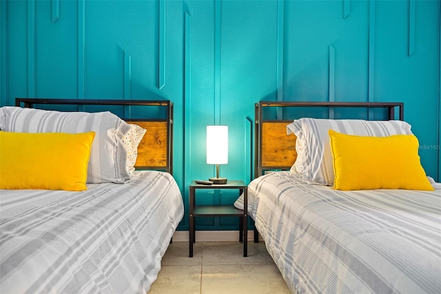 bedroom with concrete floors and a decorative wall