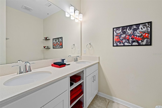 bathroom with double vanity, a sink, visible vents, and tile patterned floors