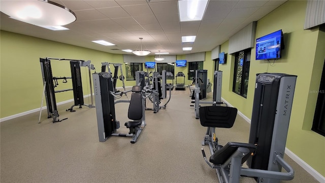 exercise room with a drop ceiling and baseboards