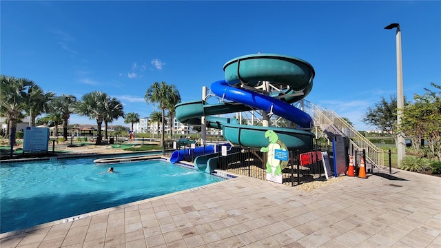 view of pool featuring a water slide and playground community