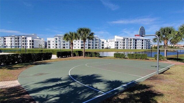 view of sport court with community basketball court, a water view, and fence