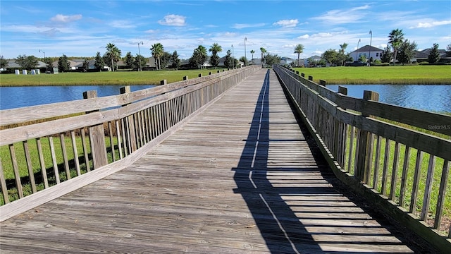 view of dock featuring a lawn and a water view