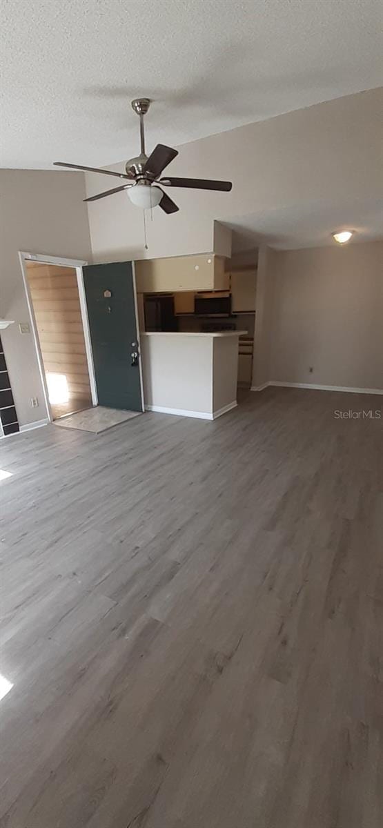 unfurnished living room featuring ceiling fan, a textured ceiling, and hardwood / wood-style flooring