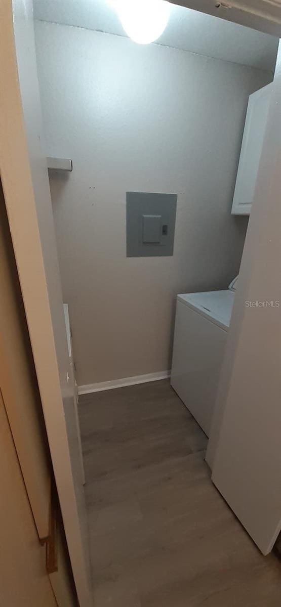 laundry area with washer / dryer, electric panel, and light hardwood / wood-style flooring