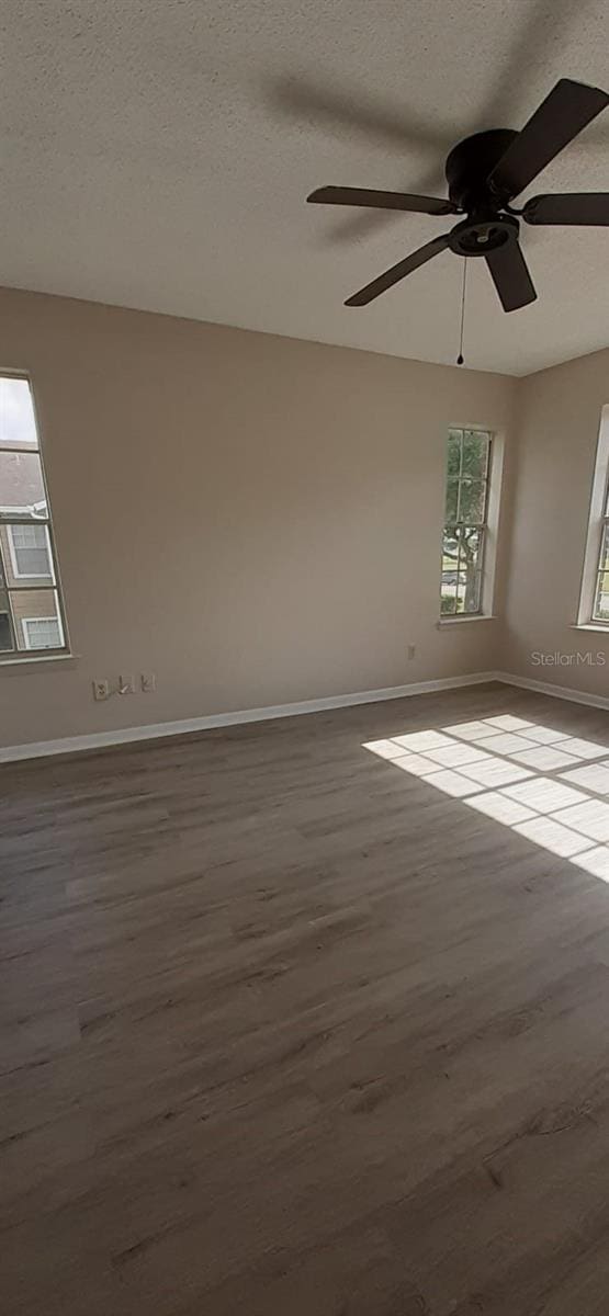 empty room with hardwood / wood-style flooring, ceiling fan, and a textured ceiling