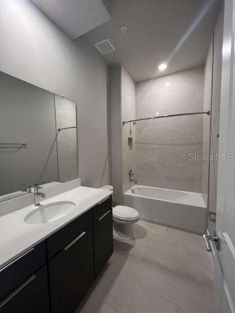 full bathroom featuring tiled shower / bath, toilet, tile flooring, and oversized vanity