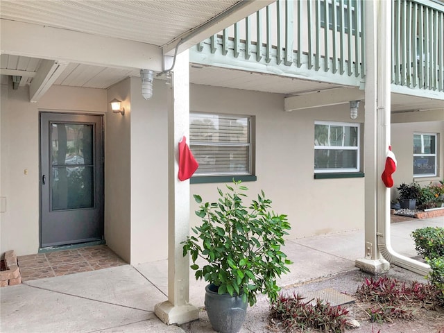 view of exterior entry with a balcony