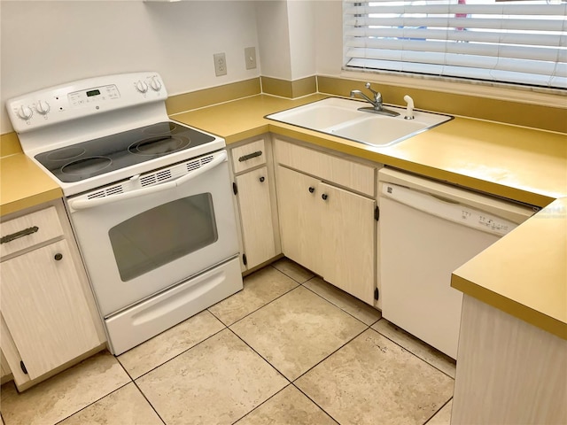 kitchen featuring sink, light tile patterned floors, and white appliances