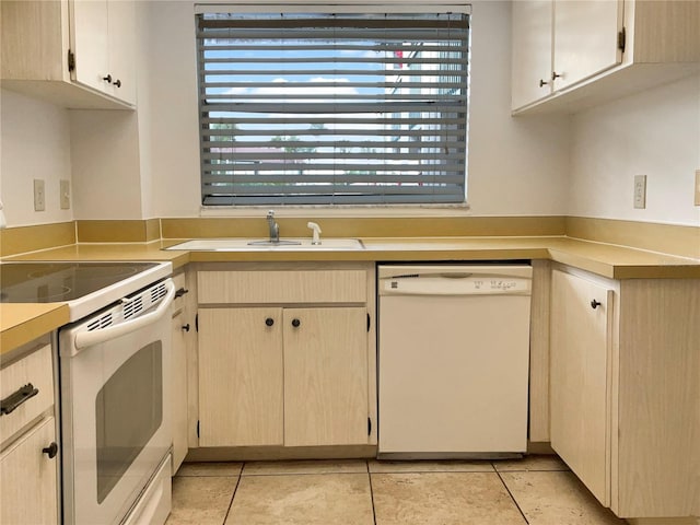 kitchen with light tile patterned floors, white appliances, a healthy amount of sunlight, and sink