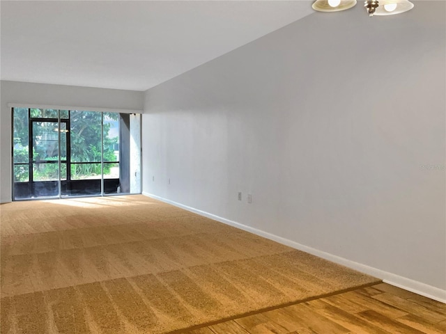 unfurnished room featuring hardwood / wood-style floors and lofted ceiling