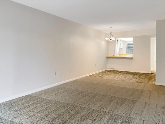 unfurnished room featuring carpet flooring and a chandelier