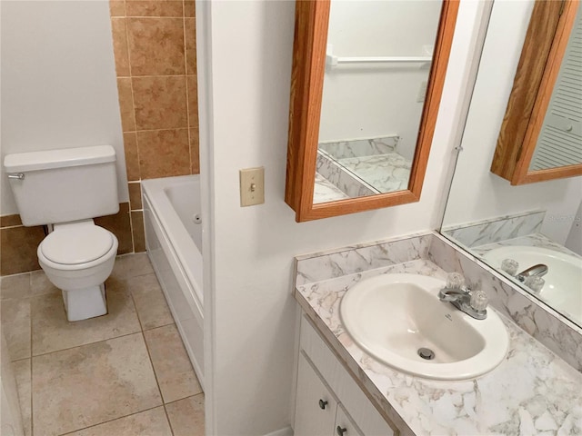 bathroom with tile patterned floors, vanity, toilet, and a tub