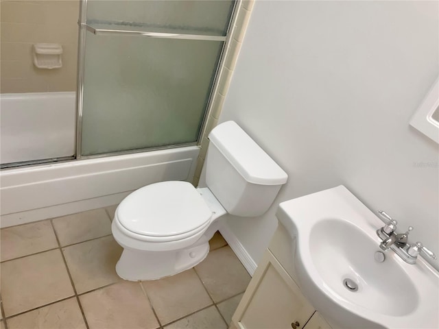 full bathroom featuring combined bath / shower with glass door, vanity, tile patterned floors, and toilet