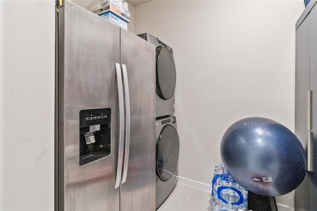 washroom with stacked washing maching and dryer and light tile patterned flooring