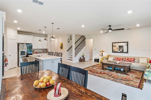 dining room with light tile patterned floors, ceiling fan, and sink