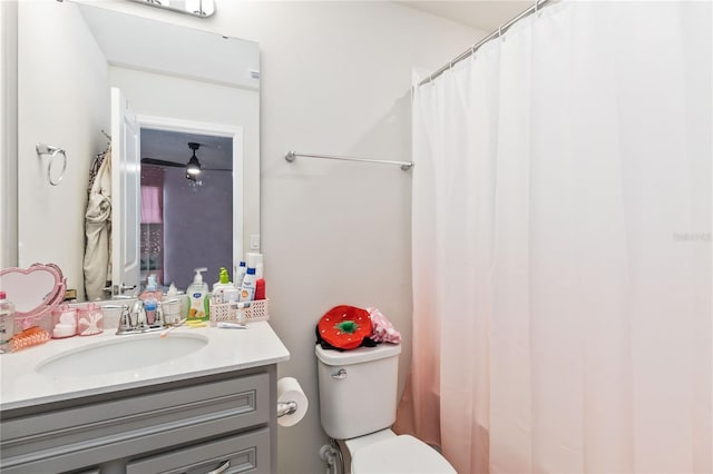 bathroom featuring curtained shower, vanity, and toilet