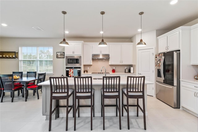 kitchen featuring pendant lighting, white cabinetry, and stainless steel appliances