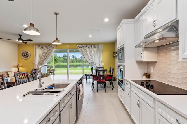 kitchen featuring pendant lighting, backsplash, light tile patterned floors, appliances with stainless steel finishes, and white cabinetry