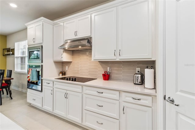 kitchen with backsplash, white cabinetry, light tile patterned floors, and stainless steel appliances