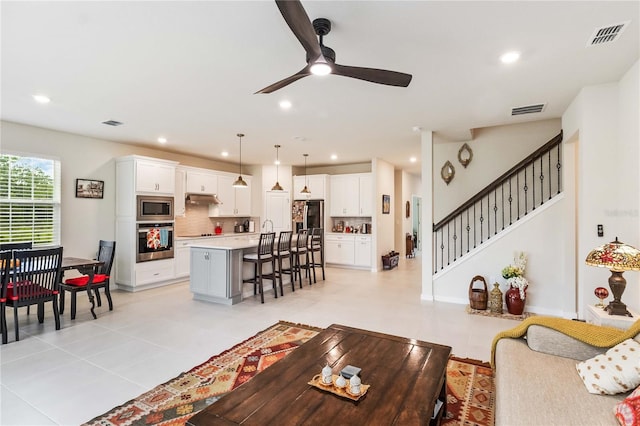 tiled living room with ceiling fan