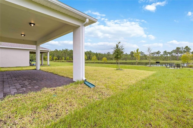 view of yard with a water view and a patio area