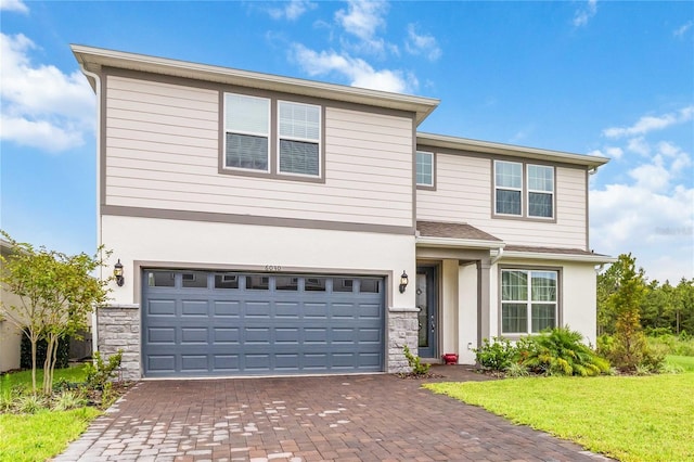 view of property featuring a front yard and a garage