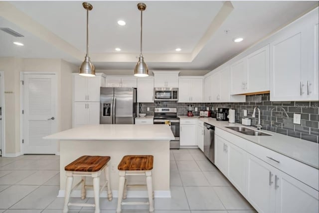 kitchen with a sink, visible vents, backsplash, appliances with stainless steel finishes, and light tile patterned floors