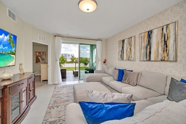 living area with wallpapered walls, visible vents, and light tile patterned floors