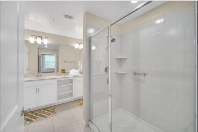 full bath featuring vanity, tile patterned flooring, visible vents, and a stall shower