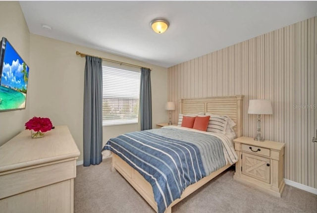 bedroom featuring baseboards and light carpet