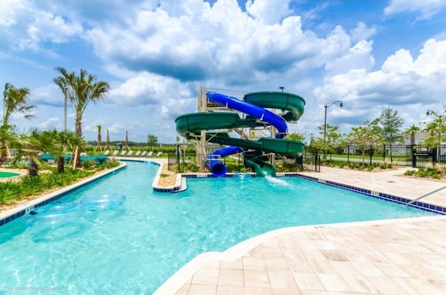 pool with a water slide and fence
