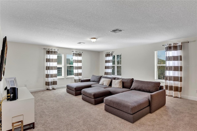 living room featuring plenty of natural light, light colored carpet, and a textured ceiling